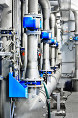 Close-up of a steel pipeline in an industrial city water treatment boiler room. Valves and pipe...