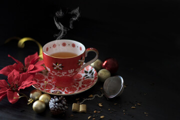 Side View of Christmas Tea Cup with Steam, shot against dark background. Chinese Tea for Christmas. Dark Food Photography for Christmas. 