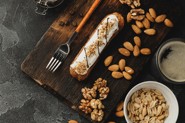 Eclair cake on dark wooden board on black table