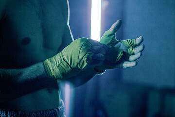 Fototapeta na wymiar the man reels up on hands bandage for boxing