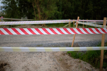 Fototapeta na wymiar Red and white tape for prohibition of passage. Access denied line, do not enter hazardous area