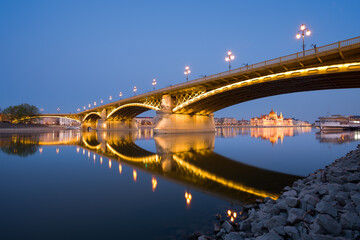 Margaret bridge in Budapest at night reflecting in still water