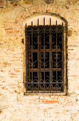 Window with metal grate on a brick wall