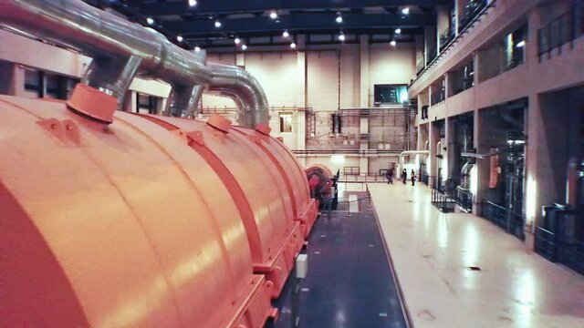 Drone flies through a giant generator turbine room at a european power plant