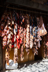 A storefront in central Damascus, Syria with an outdoor display of stacks of ethnic, local shoes...