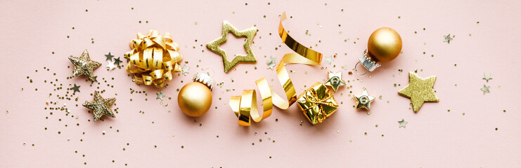 Flat lay of Celebration. Golden Christmas decorations on pink background