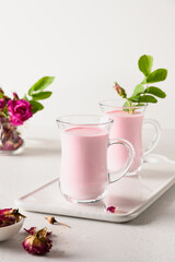 Rose moon milk in glasses on white background. Close up. Vertical.