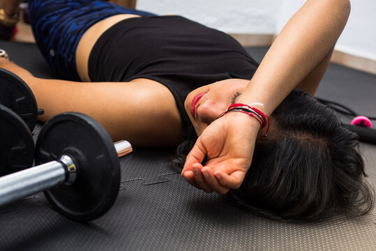 Tired after exercise and workout. Exhausted woman lying on floor breathing and resting at home. Close up tired woman. Too much working out.