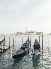 Fototapeta na wymiar Gondolas moored by Saint Mark square with San Giorgio di Maggiore church in the background - Venice, Venezia, Italy, Europe