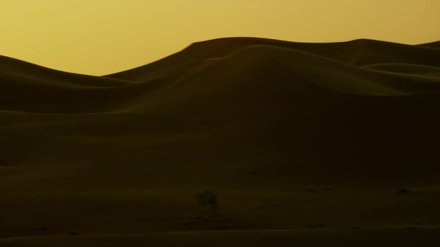 Beautiful sunset over mountains of sand dunes in the desert Dubai UAE, passing through them shoot overview of the desert dunes horizontal. the helicopter, 6-axis, Shotover F1, 8K