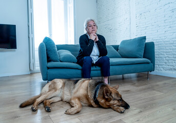 Depressed lonely senior woman in isolation at home with pet dog as only companion