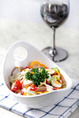 vegetable salad of tomato, cucumber, pepper , iceberg and quail eggs, white plate, vertical