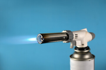 Flamethrower burner gas blow torch Ignition with blue fire flame at blue background