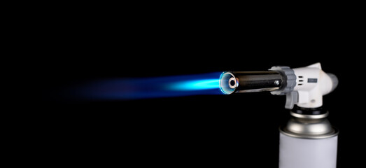 Flamethrower burner gas blow torch Ignition with blue fire flame at black background