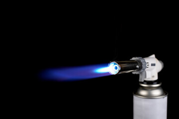 Flamethrower burner gas blow torch Ignition with blue fire flame at black background