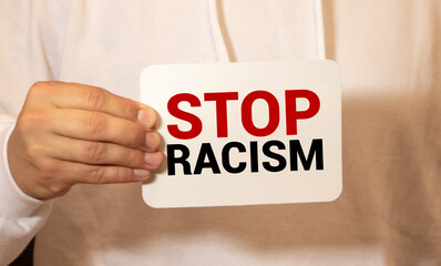Text on a small chalkboard STOP RACISM in the hands of a girl. Isolated