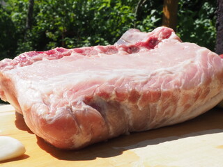 pork loin on the bone with garlic on a wooden Board. cooking in nature. against the background of...