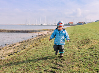 Toddler girl walking on dyke