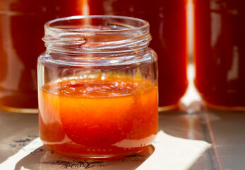 Canned apricot jam in glass jars on the windowsill.