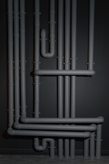 Obraz premium Complicated Gray plastic drainage pipes system on wall