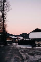 Fototapeta na wymiar A street and snow-covered houses in a rural Bavarian village in winter with snow in the evening