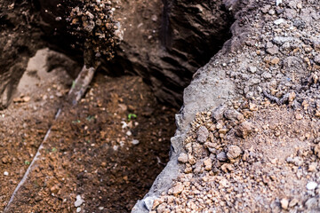 Fototapeta premium Earthworks. Shovel in the ground in the garden. A bayonet spade in the garden. Digging up the soil on the suburban area. Land works with a trench tool.
