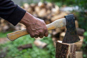 Old man splitting logs with ax
