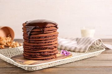 Tray with delicious chocolate pancakes on table