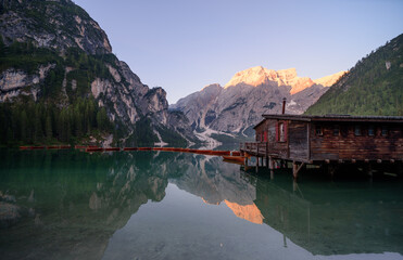 Obraz premium The Seekofel mountains and wooden boats reflected in the waters of Lake Braies