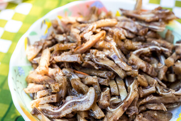 A cooked dish made from pork ears. Delicacy. The dish is on our table.