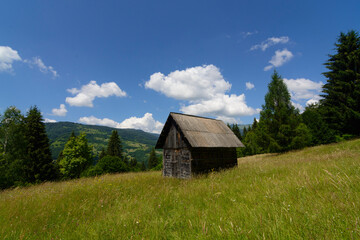 Old wooden house in mountains. Alone cabin in the mountain forest. Landscape with hause in mountains