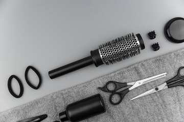 Professional hair dresser tools with copy space. Hair stylist equipment set on gray background. Scissors, brush, hairbrush, balm flat lay top view.