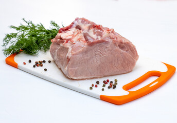 One piece of fresh pork tenderloin on a spiced cutting board before cooking. Concept on white...