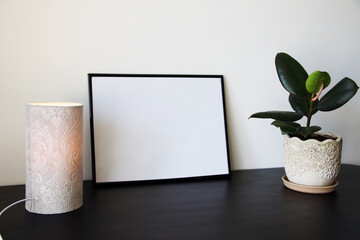 empty blank frame mockup with plant and lamp
