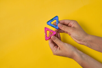 Top view of colorful magnetic building blocks on yellow background