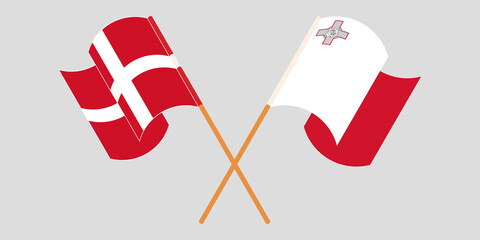Crossed and waving flags of Malta and Denmark