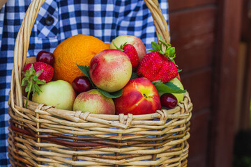 fruit basket in the hands of a girl on a wooden background