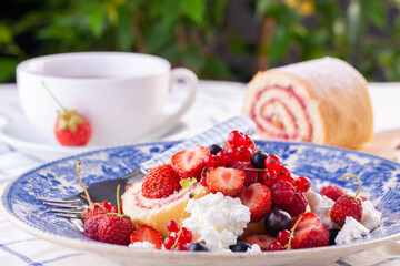 dessert with fresh berries on a white background. Sweet roll