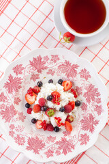 Obraz na płótnie Canvas dessert with fresh berries on a red vintage plate. Farm cottage cheese
