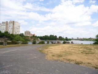 View of the city from two banks. High-rise buildings, blue sky, river and asphalt road in Ottawa,...