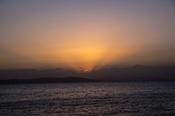 Fototapeta premium Twilight, dusk cloudy sky over sea water, dark land horizon