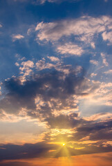 The last rays of the sun at sunset from under the storm clouds.