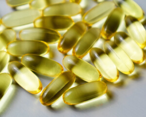Close up fish oil capsules. Omega 3 arranged on wooden background. Copy space for your text.