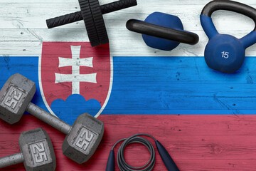 Slovakia sports club concept. Top view of heavy weight plates with iron bar on national background.