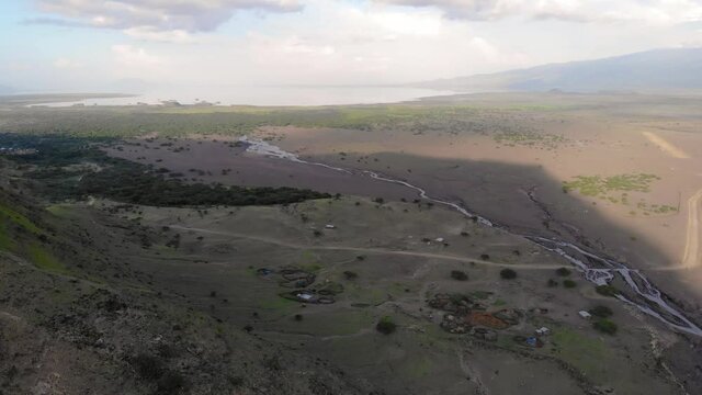 Aerial Flyby View on the Maasai village in on the coast of Natron Lake front of the Ol Doinyo Lengai, Mountain of God in the Maasai language, Engare Sero village in Arusha Region i the Northern
