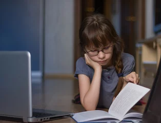 Poster Leuk meisje dat thuis leest en studeert via internet © Albert Ziganshin
