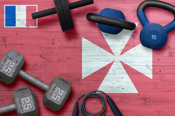 Wallis And Futuna sports club concept. Top view of heavy weight plates with iron bar on national...