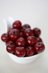 Juicy cherries in whita bowl close up isolated on white background