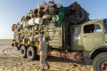 Heavily loaded truck transporting goods and people in the Sahara desert, Chad