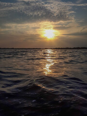 Obraz premium Scenic view of ocean waves in motion against sunset sky with reflections in Grado, Italy. 